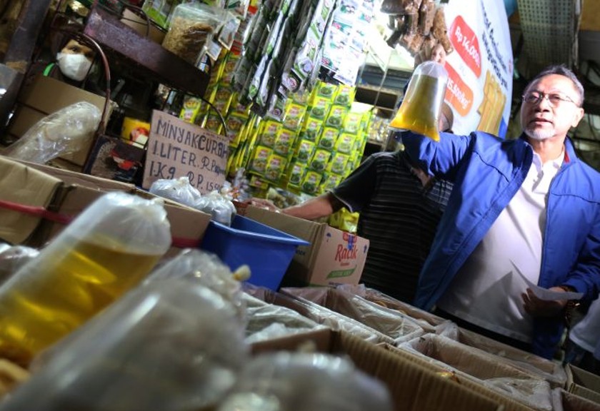 Menteri Perdagangan Zulkifli Hasan menunjukkan minyak goreng curah saat mengunjungi Pasar Kramat Jati. (Antara)