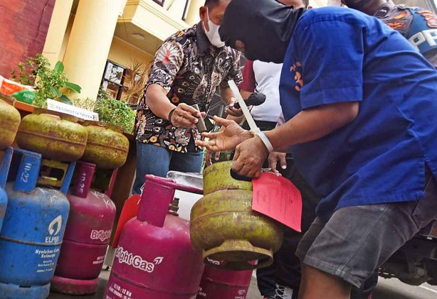 Tersangka penyalahgunaan gas LPG bersubsidi berinisial MU (kanan) memperagakan cara memindahkan isi gas saat ekspos di Mapolda Banten, di Serang, Jumat (15/7/2022).

(ANTARA FOTO/Asep Fathulrahman)