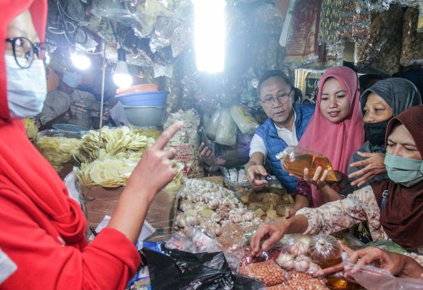 Menteri Perdagangan Zulkifli Hasan (tengah) berbincang dengan pedagang saat meninjau harga bahan pokok di Pasar Cibinong, Kabupaten Bogor, Jawa Barat, Jumat (22/7/2022). (ANTARA FOTO/Yulius Satria Wijaya/pras)