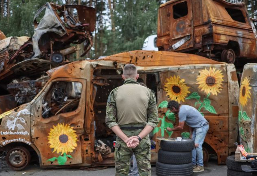 Seniman AS Trek Kelly melukis bunga-bunga matahari pada tumpukan bangkai mobil korban serangan Rusia yang dikumpulkan di Irpin, Kyiv, Ukraina, Rabu (10/8/2022).

(ANTARA FOTO/ REUTERS/Gleb Garanich)