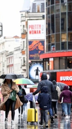 Orang-orang berjalan melewati Cineworld di Leicester's Square di London, Inggris, beberapa waktu lalu.