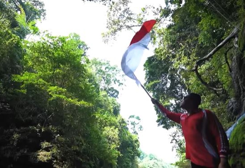 Influencer Arief Muhammad saat kibarkan merah putih di Green Canyon, Jawa Barat, Indonesia. (YouTube/Arief Muhammad)