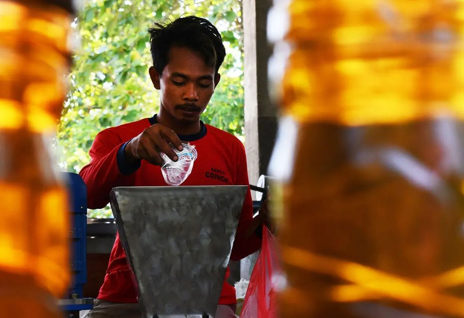 Pekerja memasukkan sampah gelas plastik ke mesin pencacah plastik untuk diproses menjadi bahan bakar minyak (BBM) jenis solar di Kabupaten Madiun, Jawa Timur, Selasa (13/9/2022).

(ANTARA FOTO/Siswowidodo)